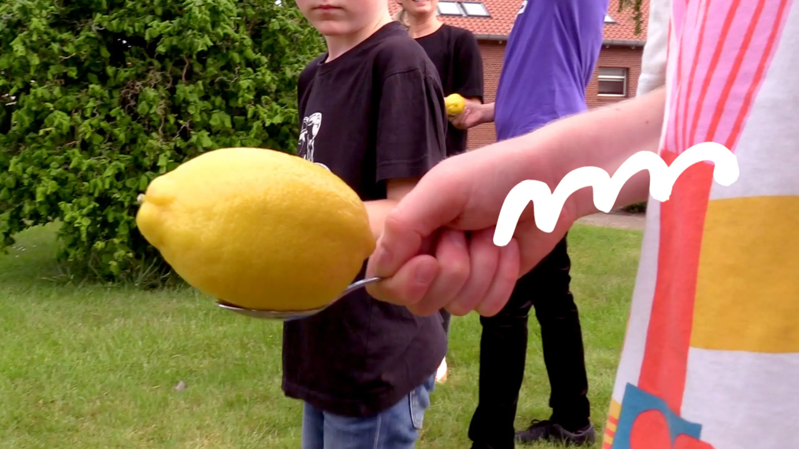hand holding a spoon with lemon on it