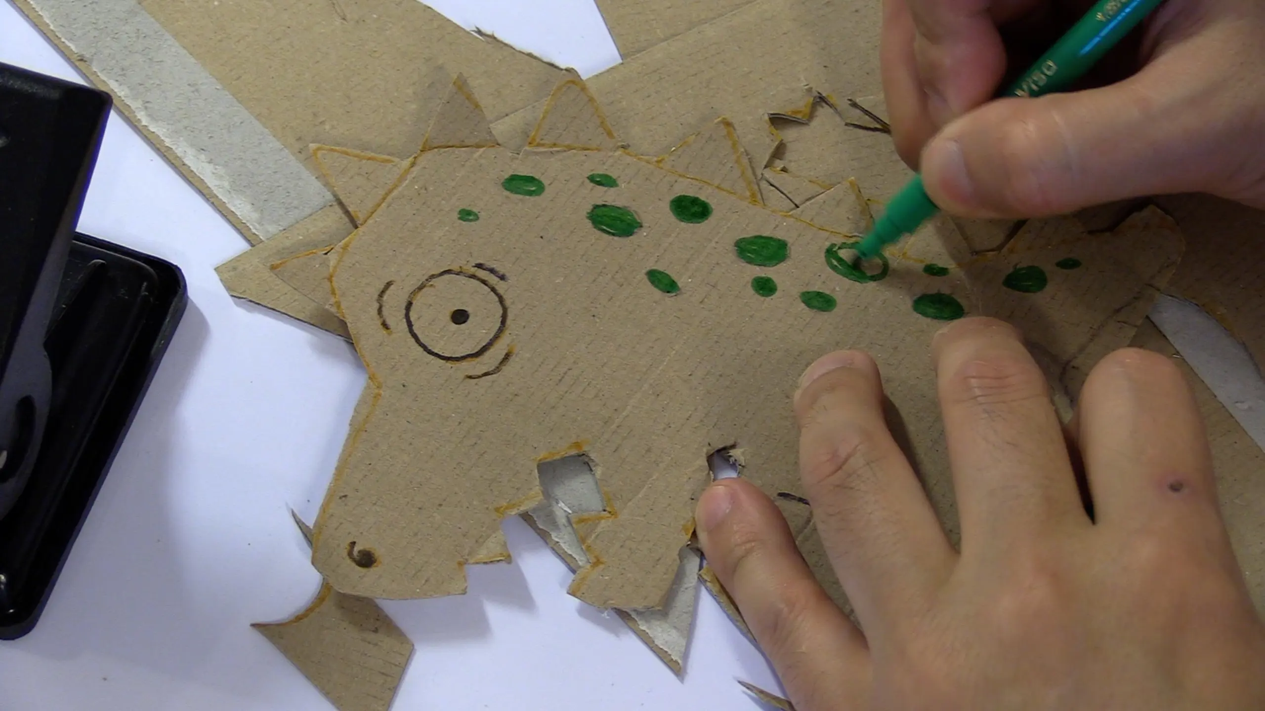 child coloring dinosaur shape made with cardboard