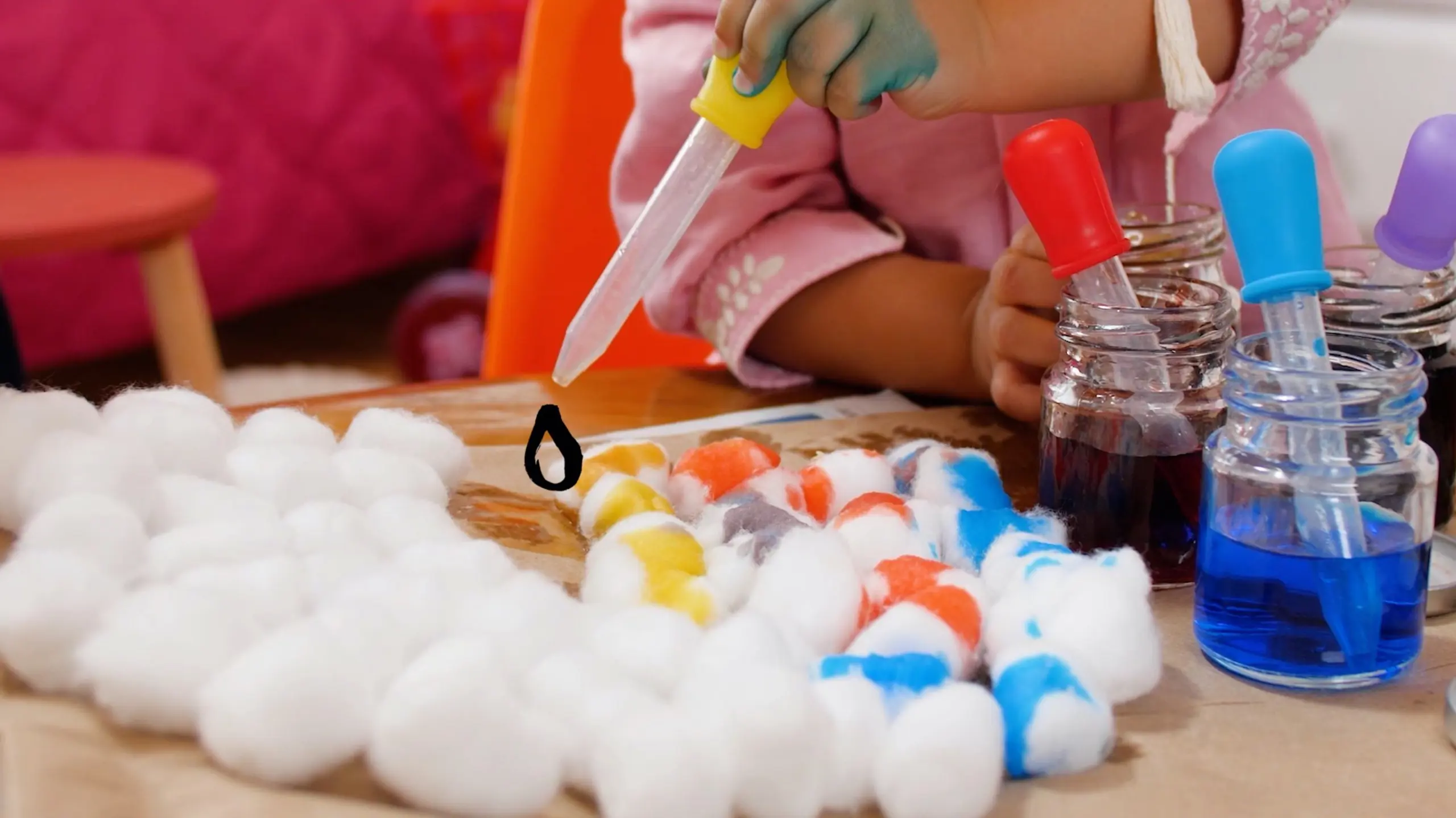 child dropping colour drops on cotton 