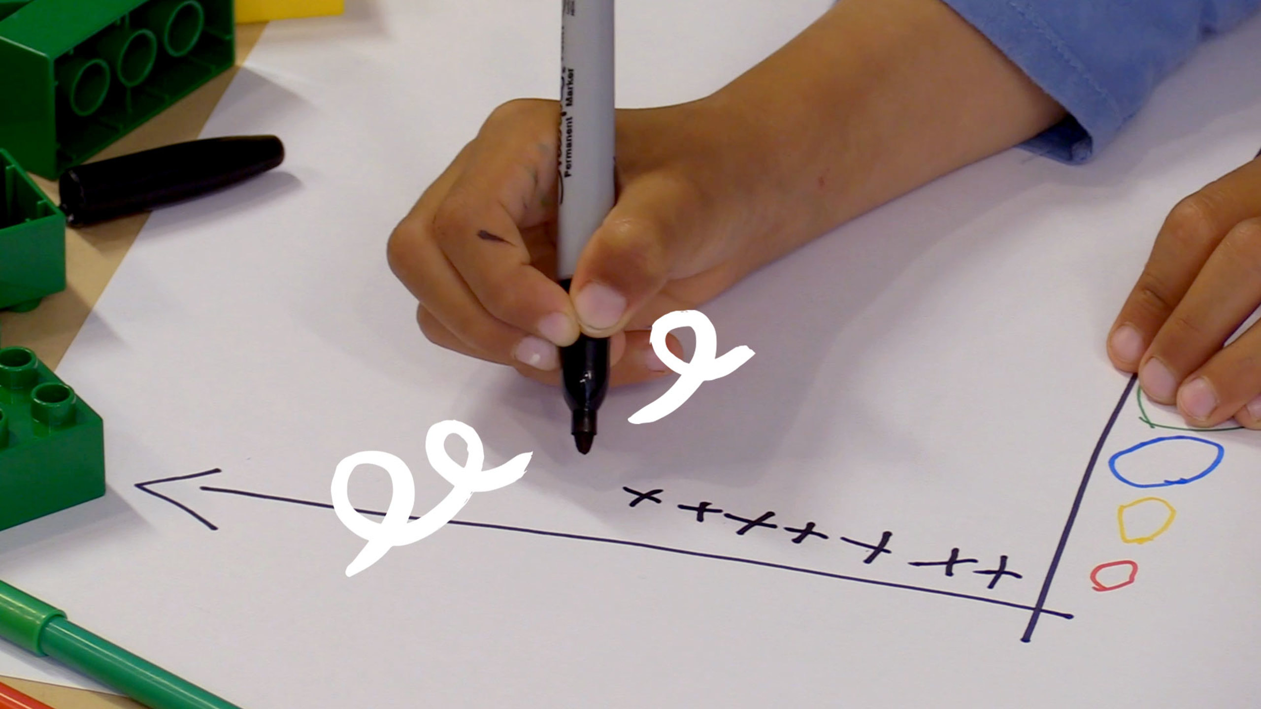 Child drawing a chart on a piece of paper